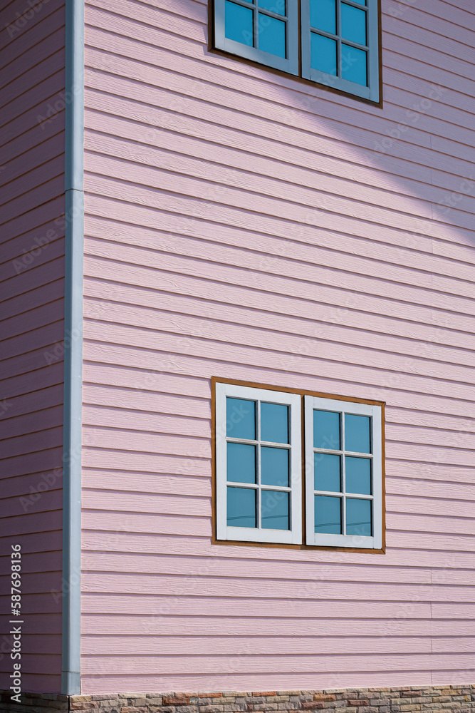 Sunlight and Shadow on surface of glass and wooden Windows on artificial wood Wall of Pastel pink Vintage House, Perspective side view and vertical frame 