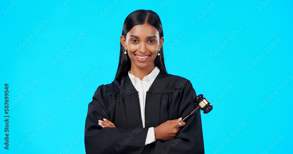 Lawyer, face and happy woman with gavel in studio, blue background and color backdrop. Portrait, female judge and legal attorney with arms crossed, smile and confidence for justice of constitution Lawyer, face and happy woman with gavel in studio, blue background and color backdrop. Portrait, female judge and legal attorney with arms crossed, smile and confidence for justice of constitution