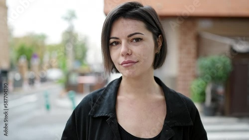 Young caucasian woman standing with serious expression saying no with finger at street photo