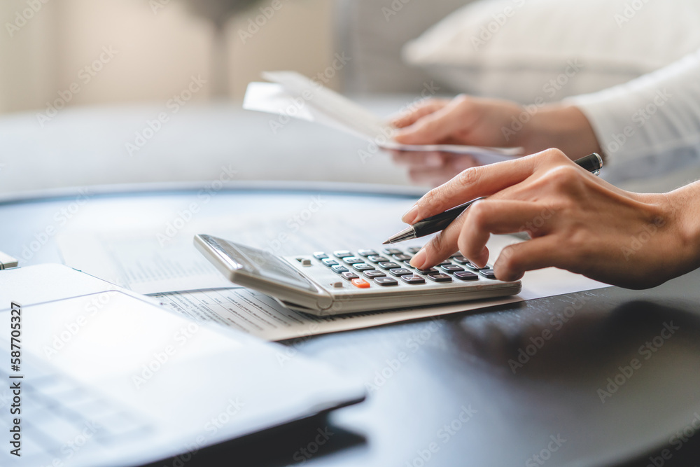 Women business people use calculators to calculate the company budget and income reports on the desk in the office. Women business people use calculators to calculate the company budget and income reports on the desk in the office.