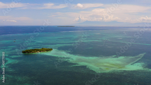 Tropical island and blue sea with a coral reef against the sky and clouds. Summer and travel vacation concept. Panglao, Philippines. photo