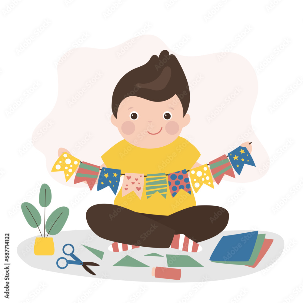 Little caucasian boy cuts and glues handmade crafts. Smart child made flags to decorate room or christmas tree. Education, creativity and art.