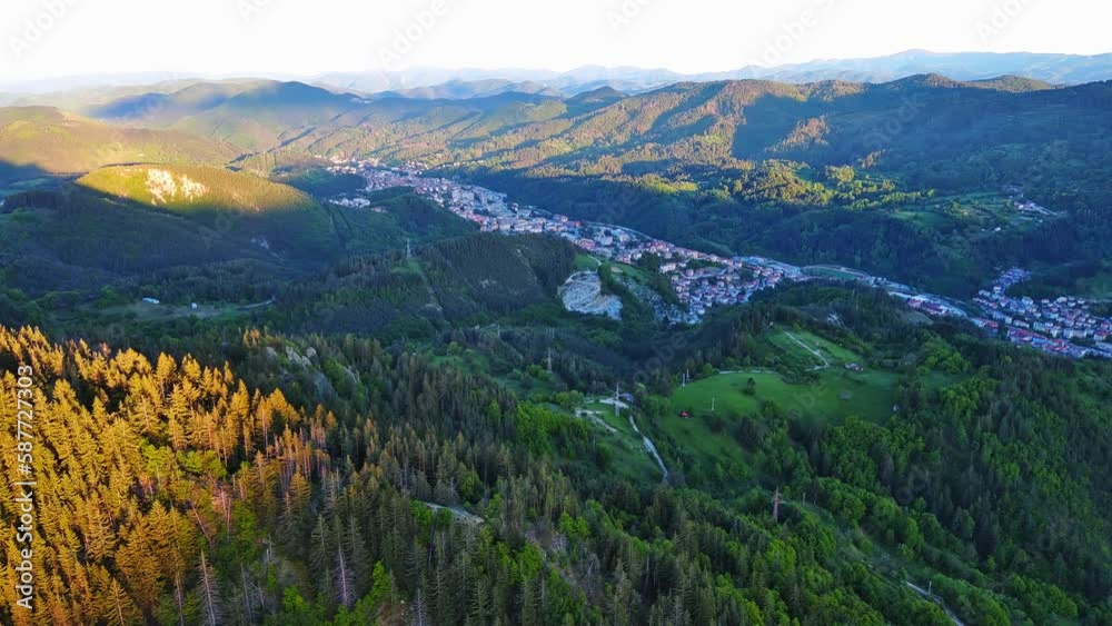 View from rock to town of Smolyan with meadows for cattle walking and houses between mountain range of Rhodope Mountains View from rock to town of Smolyan with meadows for cattle walking and houses between mountain range of Rhodope Mountains