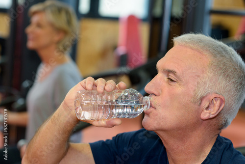 middle age man driking bottled water photo