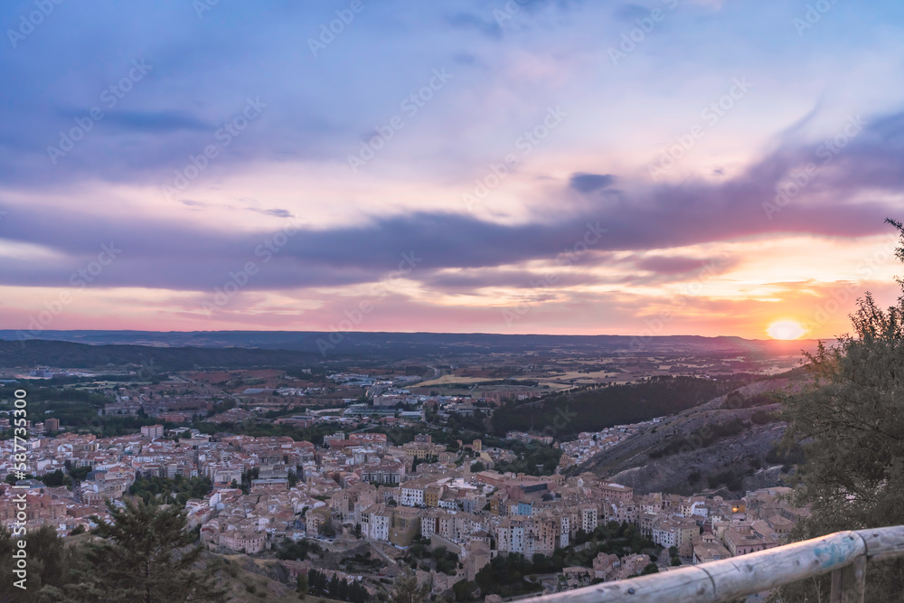 Sunset in the town of Cuenca, with clouds of different colors and the sun hiding on the horizon. Cuenca, Spain