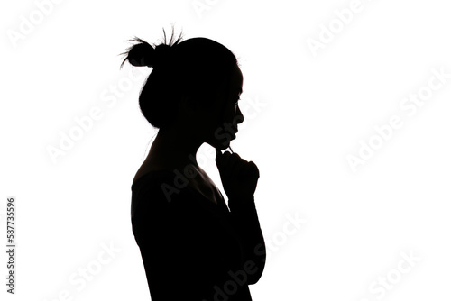 Black backlit silhouette of head and shoulders of an oriental woman from the side outlined by light