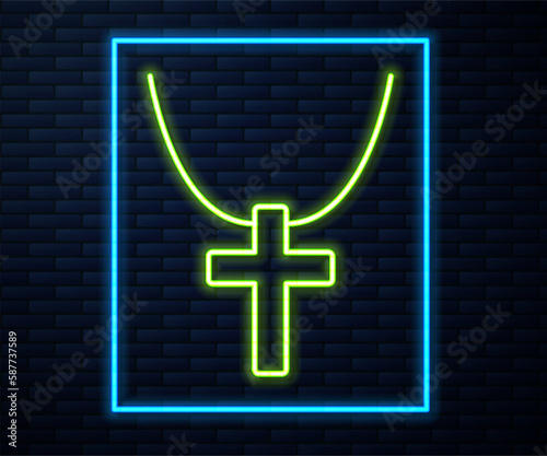 Glowing neon line Christian cross on chain icon isolated on brick wall background. Church cross. Vector