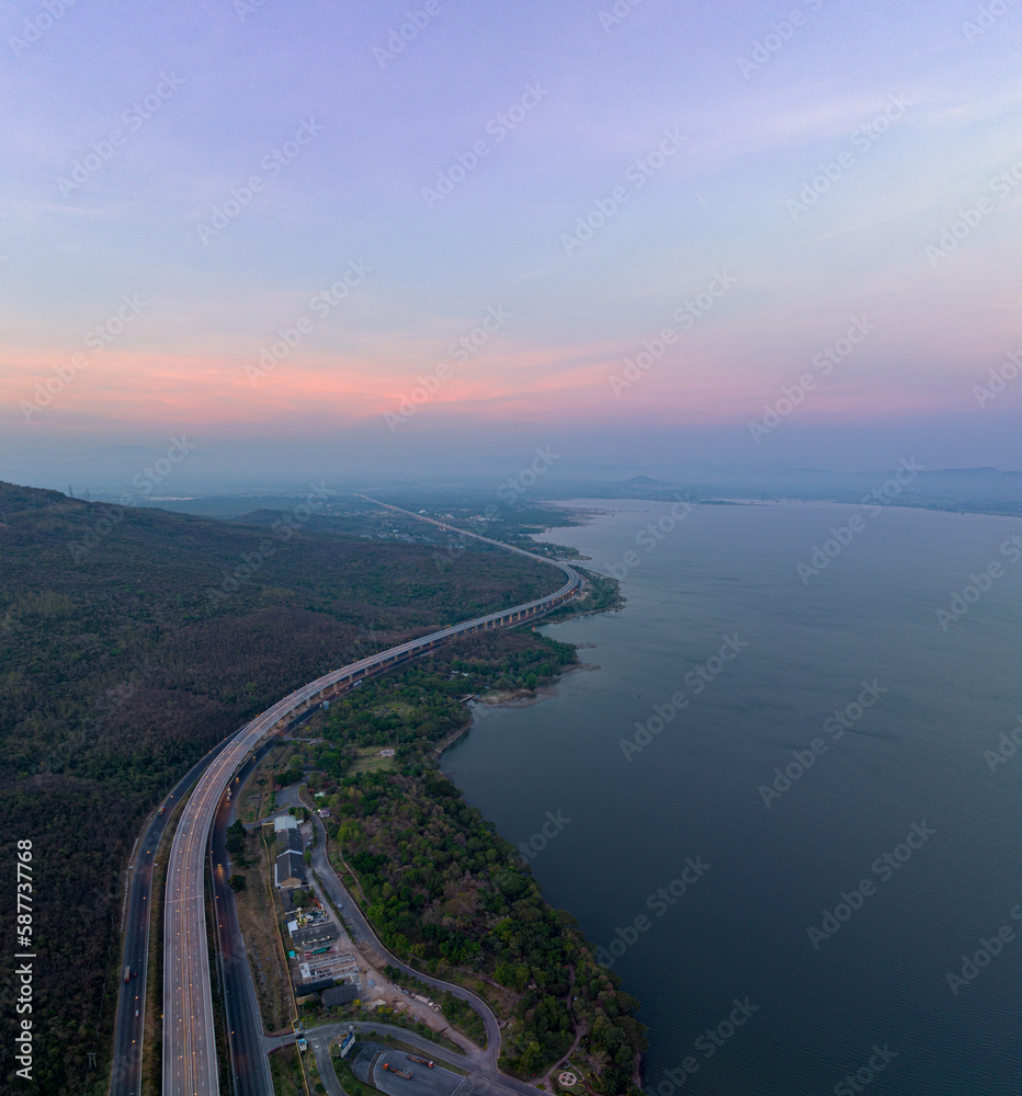 .aerial view light on super highway Along the Lam Takhong Dam at twilight..view of natural scenery beside the road..dams and wind turbines that generate electricity..blue water and beautiful sky .aerial view light on super highway Along the Lam Takhong Dam at twilight..view of natural scenery beside the road..dams and wind turbines that generate electricity..blue water and beautiful sky