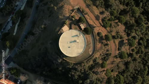 Aerial top view of white round water reservoir with landscape of Santa Coloma de Gramenet district in Barcelona photo