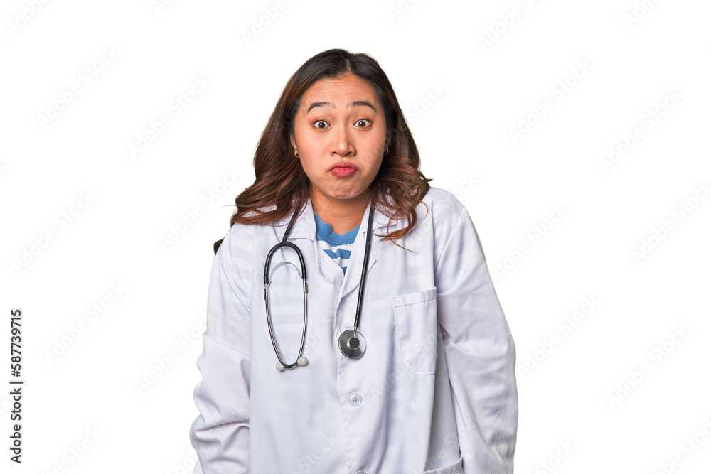 A young asian doctor woman shrugs shoulders and open eyes confused. A young asian doctor woman shrugs shoulders and open eyes confused.