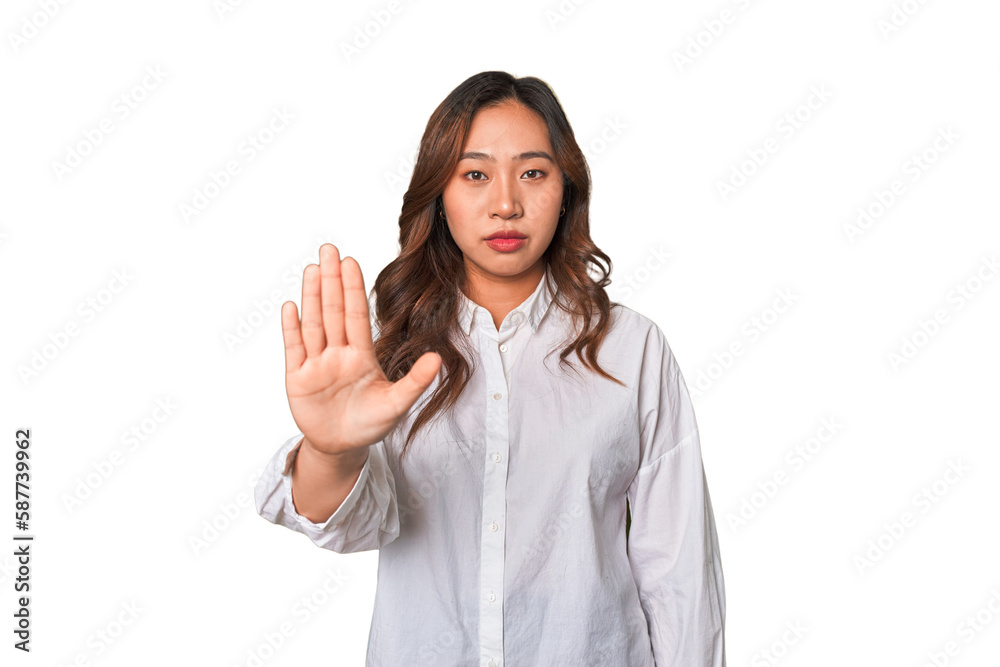 A young chinese woman standing with outstretched hand showing stop sign, preventing you. A young chinese woman standing with outstretched hand showing stop sign, preventing you.