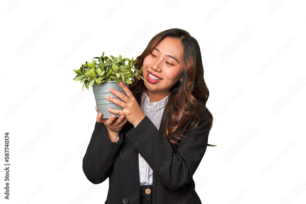 A powerful Chinese businesswoman holds a thriving plant, symbolizing her commitment to sustainable and responsible business practices. A powerful Chinese businesswoman holds a thriving plant, symbolizing her commitment to sustainable and responsible business practices.