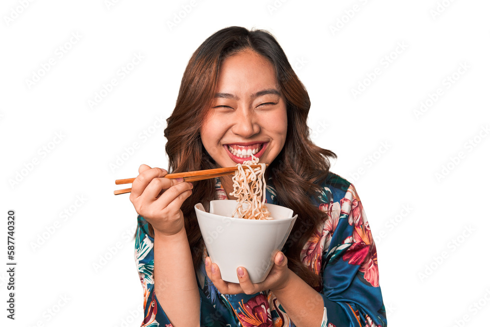 Happy young Asian woman eating noodles with chopsticks. Happy young Asian woman eating noodles with chopsticks.