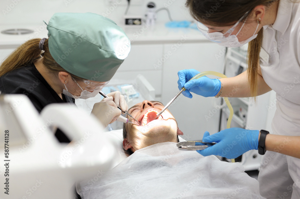 hands of doctor hold key nozzle and piezoelectric scaler removal of