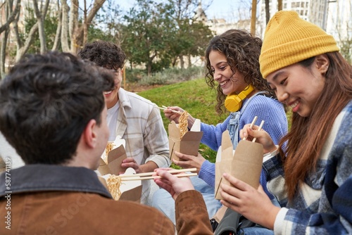 Friends from diverse cultures enjoy noodles and laughter. © Asier