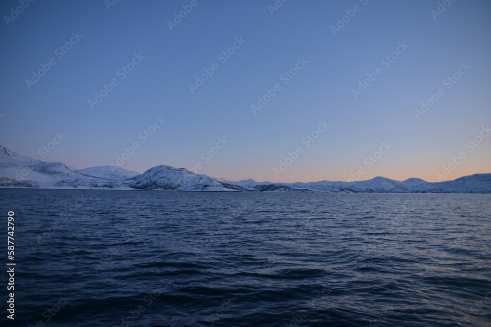 Mountains in the northern part of Norway, at the outlet to the ocean. Incredible sunset