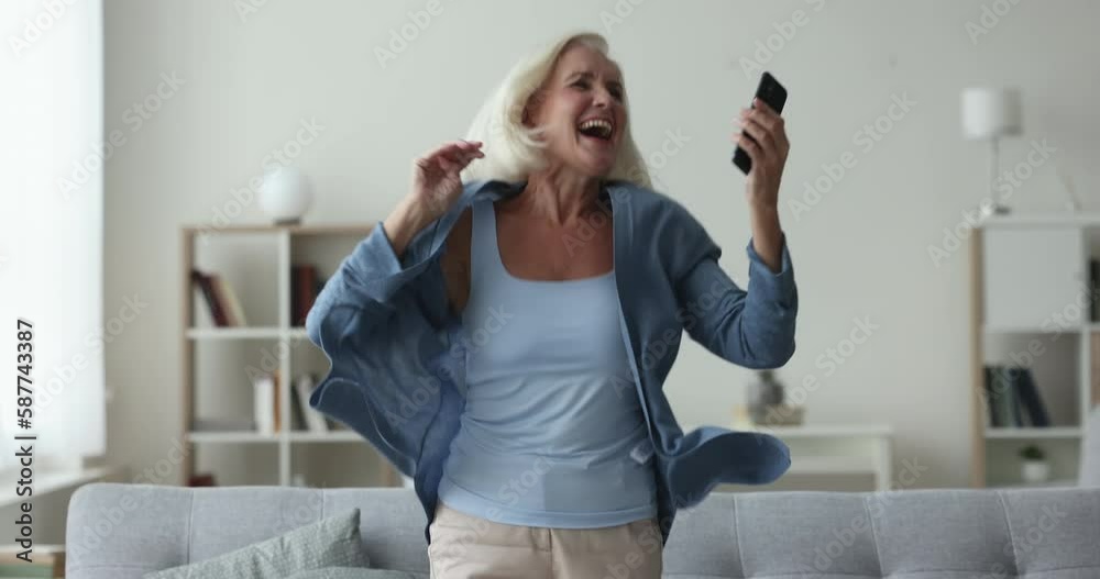 Overjoyed older woman get great news jumps celebrate success, bank mortgage approval, sell-out, good profitable commercial offer, on-line bet, auction or lottery victory. Results, relish moment of win Overjoyed older woman get great news jumps celebrate success, bank mortgage approval, sell-out, good profitable commercial offer, on-line bet, auction or lottery victory. Results, relish moment of win