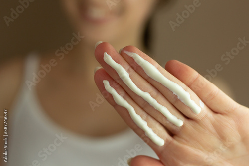 A person applying the correct amount of sunscreen for face and neck  three finger lengths .
