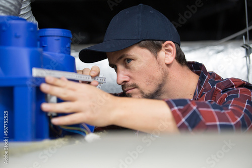 a plumber is measuring pipe