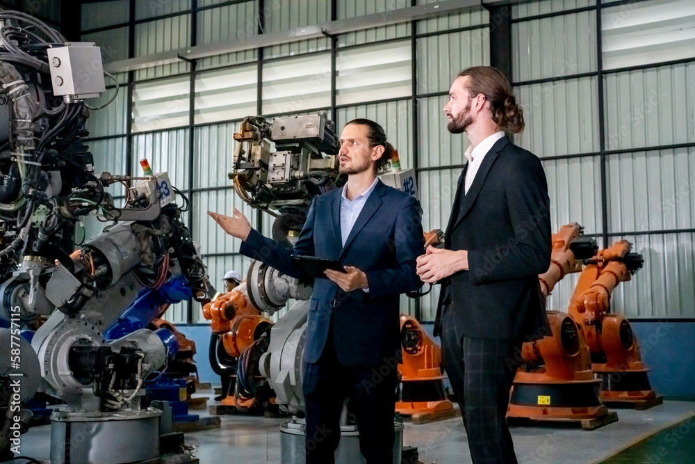 Business people meeting in factory storehouse with machine and robot arms. Business people meeting in factory storehouse with machine and robot arms.