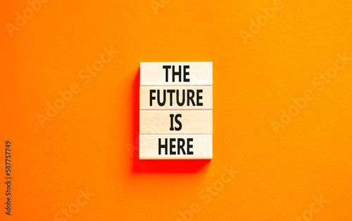 The future is here symbol. Concept words The future is here on wooden block. Beautiful orange table orange background. Motivational business the future is here concept. Copy space.
