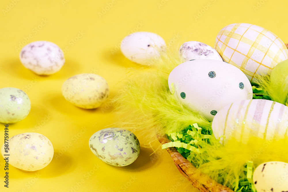 Easter nest with eggs and feathers on a yellow background close-up. Minimal concept.