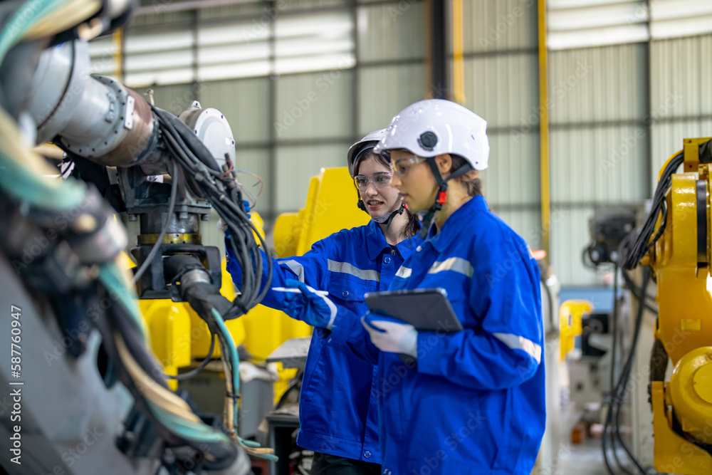 Engineer inspecting automatic robot arms and machines in factory. Engineer inspecting automatic robot arms and machines in factory.