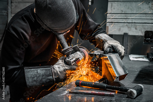 Fototapet worker grinding a piece of metal
