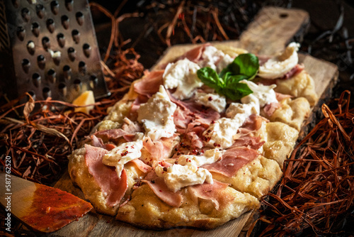 Delicious rustic homemade pinsa style pizza with mozzarella, basil leaf, parmigiano cheese and tomato sauce