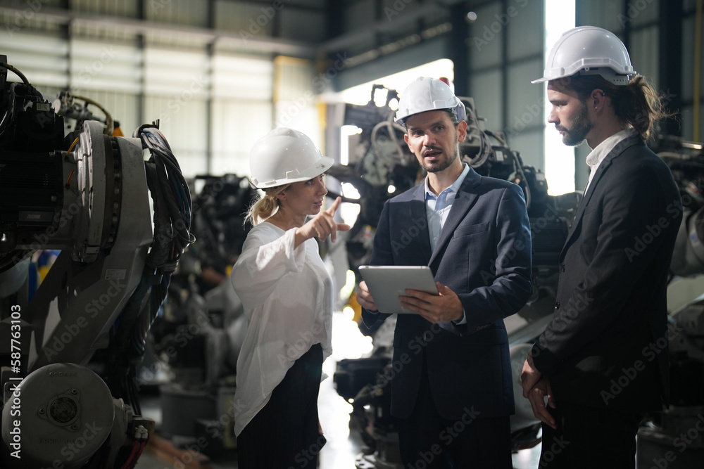 Engineer inspecting automatic robot arms and machines in factory. Engineer inspecting automatic robot arms and machines in factory.