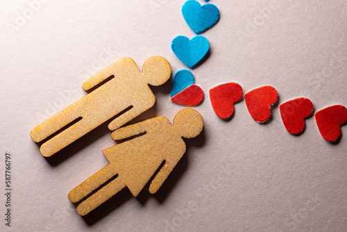 Male and female love LGBT. In marriage, family icons. Couple of lovers. A woman and a man are holding hands. Wooden people with paper blue and red hearts