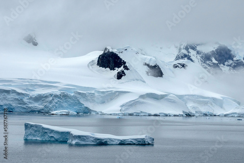 Iceberg with stunning mountainous backdrop of Wilhelmina Bay in Antarctica photo