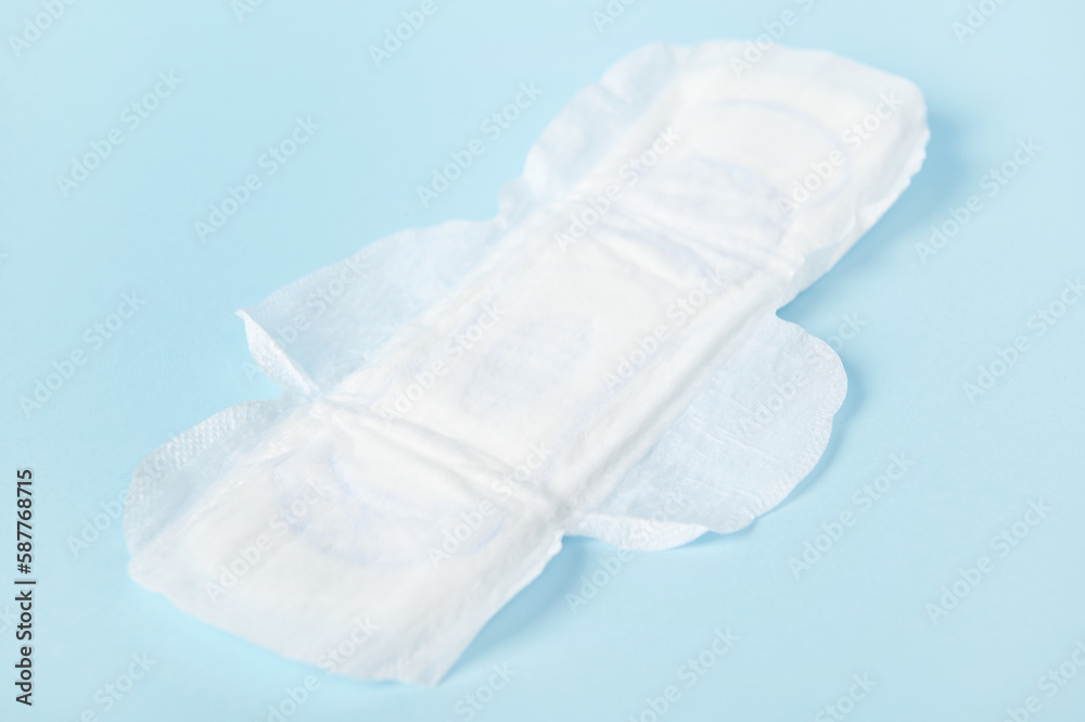 Close-up white clean women's pads isolated on blue pastel color background. The concept of women's health and menstruation Close-up white clean women's pads isolated on blue pastel color background. The concept of women's health and menstruation