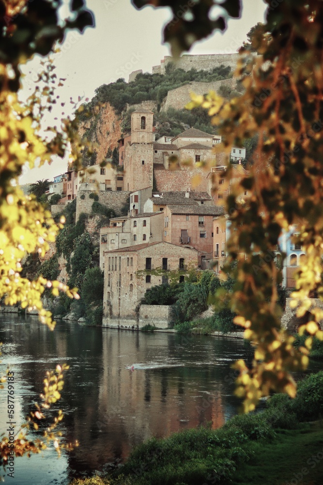 Village on the river banks with out of focus trees in front