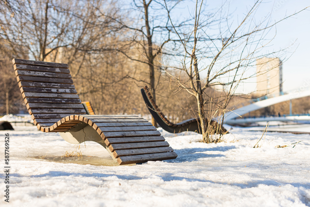 wooden deck chair in the park in winter wooden deck chair in the park in winter
