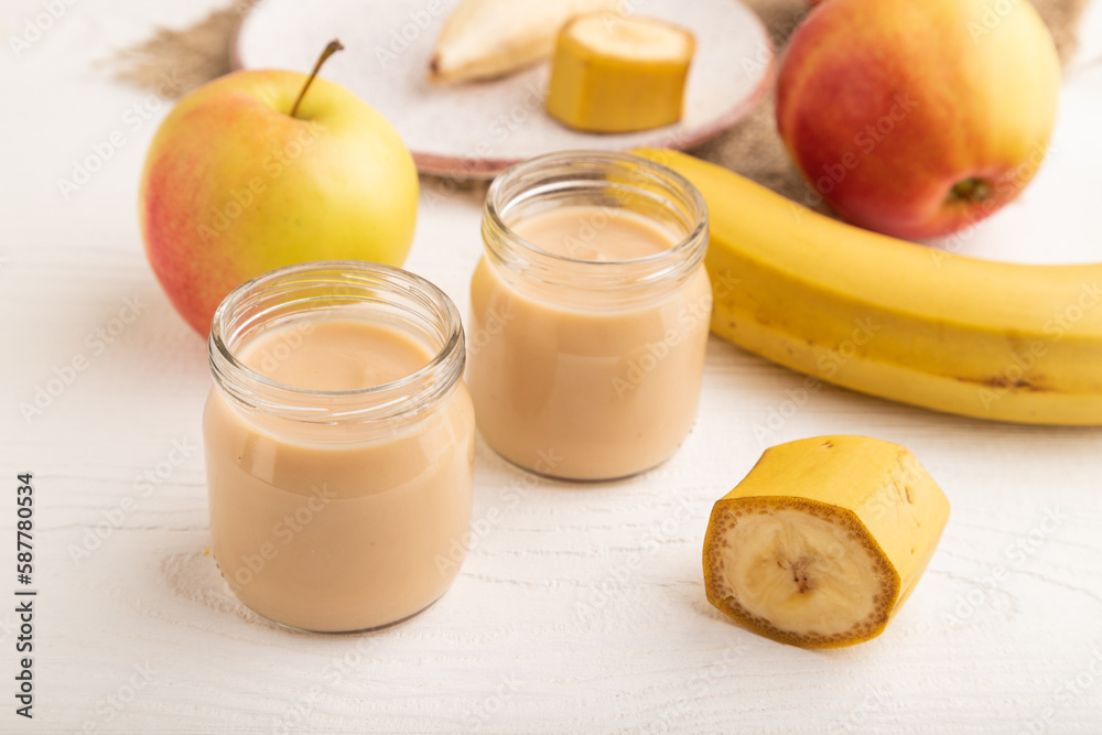Baby puree with fruits mix, apple, banana infant formula in glass jar on white, side view Baby puree with fruits mix, apple, banana infant formula in glass jar on white, side view