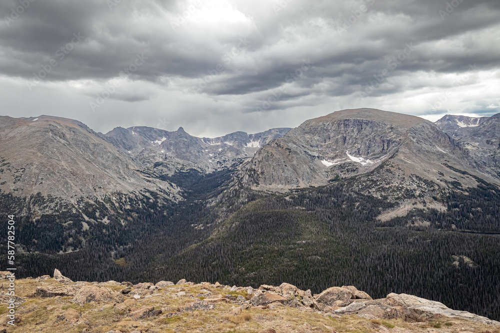 Rocky Mountain landscape and evergreen forest valleys in Colorado with dark storm louds.