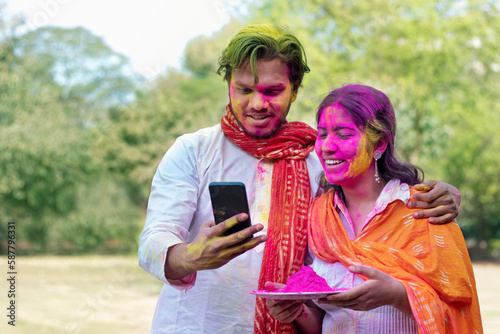 Couple with holi colours taking a self portrait