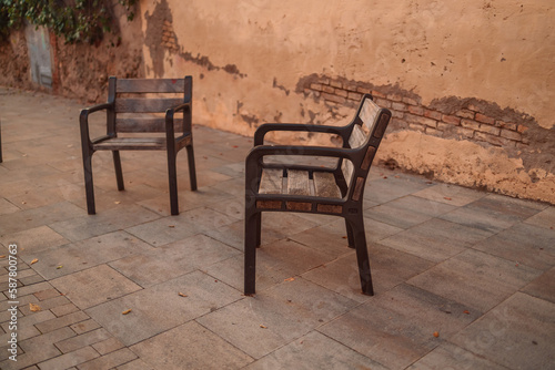 Old outdoor seating chairs near the old building wall.Garden or outdoor furniture. Barcelona  Catalonia  Spain  Europe. High quality photo. 