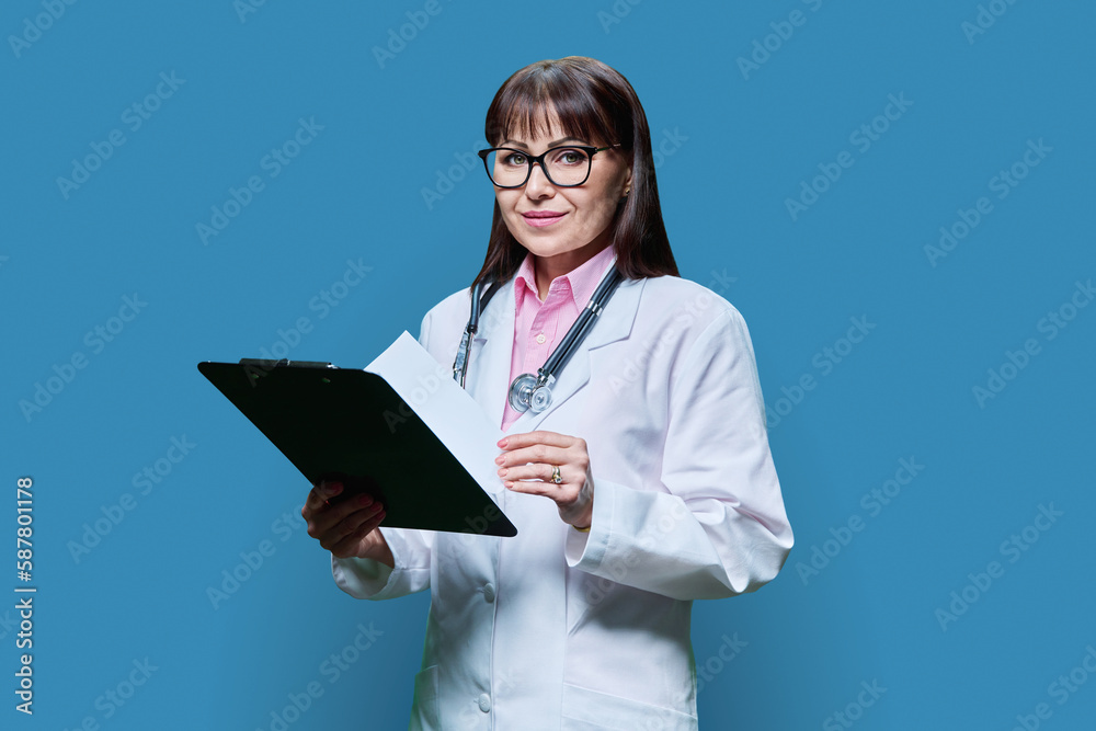 Female doctor with clipboard on blue studio background Female doctor with clipboard on blue studio background