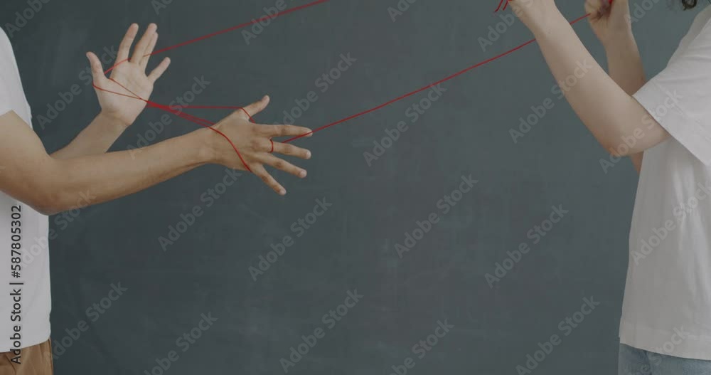 Unrecognizable girl and guy pulling strings wrapped around hands
