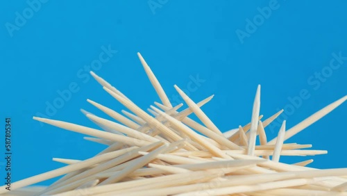 A pile of rotating wooden toothpicks on a blue background. photo