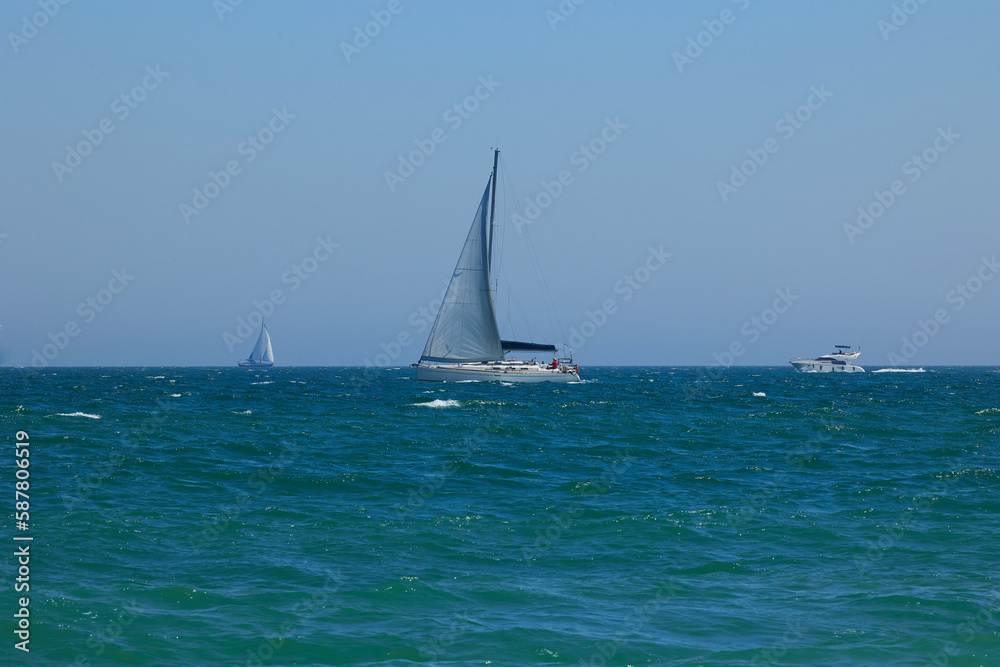 Blue Mediterranean Sea, clear skies and a sailing ship with white sailing. Regata