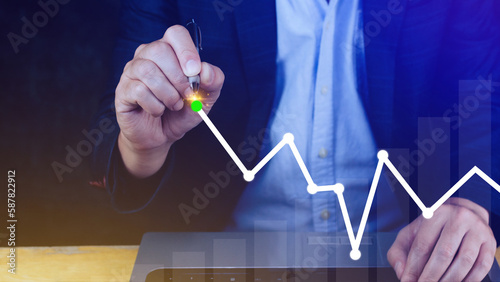 Businessman drawing growth curve, growth forecast chart, bussiness success concept. Hand drawing a graph representing increasing profits.