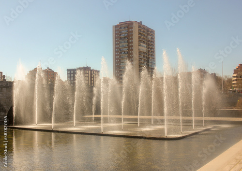 fountains in river Manzanares in Madrid with a building behind