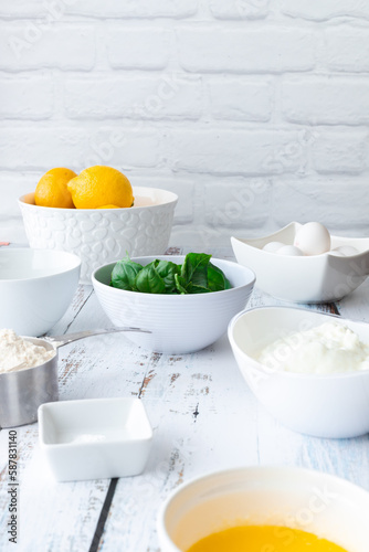 Basil and lemon cake in front of a white brick