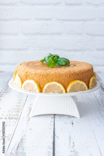 Basil and lemon cake in front of a white brick