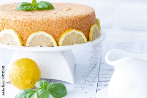 Basil and lemon cake in front of a white brick