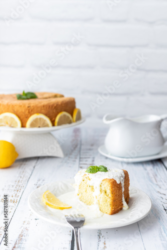 Basil and lemon cake in front of a white brick