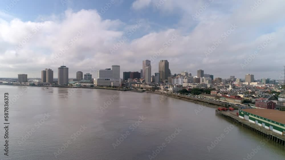 Aerial Shot Of Office Buildings In Financial City District, Drone Flying Forward Over Second-Longest River Under Clouds - New Orleans, Louisiana Aerial Shot Of Office Buildings In Financial City District, Drone Flying Forward Over Second-Longest River Under Clouds - New Orleans, Louisiana